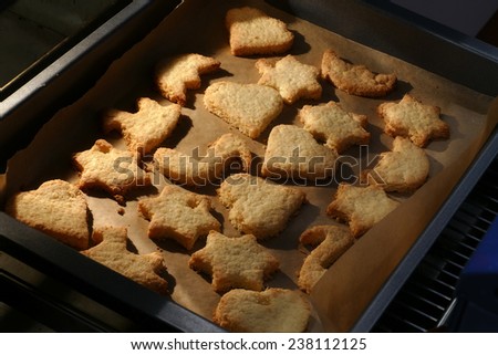 homemade cookies, stars and hearts on a baking tray fresh out of the oven