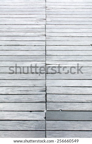 background texture wood, old footbridge from weathered gray planks, one board was renewed, bubble gum in a gap