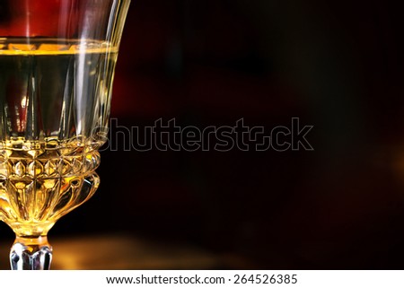 part of a wine glass at a romantic candle light dinner, blurred dark background with copy space