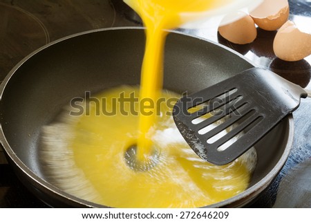 beaten egg is poured into the pan to fry scrambled eggs