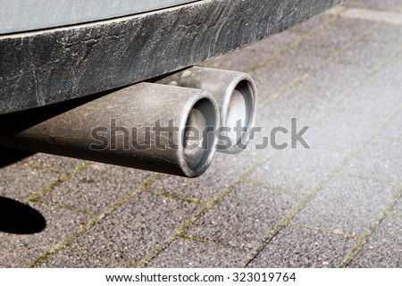 dirty dual exhaust pipes of a car, failed emission test
