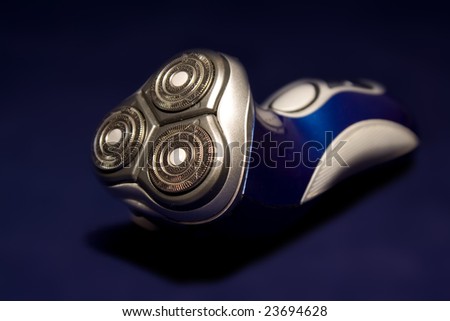 A close-up on an electric shaver head with a blue background