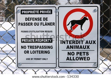 Bilingual no trespassing and no pets sign
