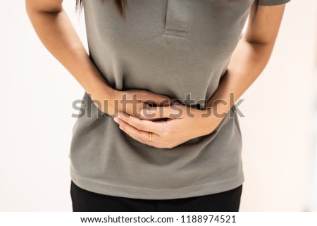 Woman with stomach pain on white background.Hand touching on stomach symptom of stomachache or menstruation pain.