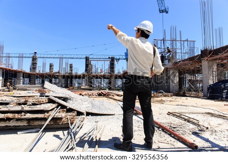 Engineer on construction site with blue sky background.