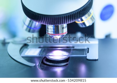Close up and soft focus of objective lens microscope in laboratory.Blue tone.