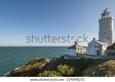A British lighthouse with a lighthouse keeper\'s cottage on the headland at Start Point, South Devon, UK.