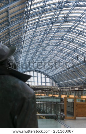 LONDON, UK - OCTOBER 15: The canopy of St Pancras International station in London over the shoulder of the John Betjeman statue welcoming passengers shown on October 15, 2014 in London, UK