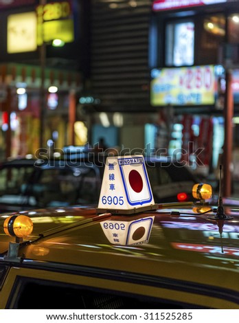 TOKYO, JAPAN - AUGUST 6: Closeup of a lit taxi sign on the roof of a yellow Japanese taxi on call at night shown on August 6, 2015 in Tokyo, Japan