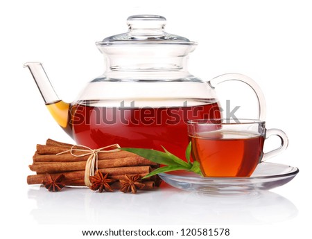 Teapot and cup of tea with green leaves and cinnamon sticks isolated on white