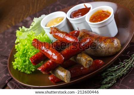 Grilled assorted sausages with sauces, salad and rosemary