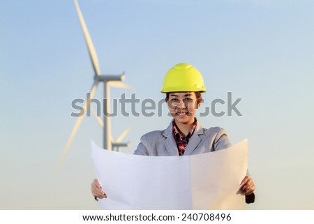 portrait women asia engineer working and holding blueprints at wind turbine farm Power Generator Station