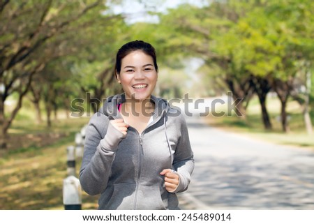 Running woman. Female runner jogging during outdoor  on road .Young mixed race girl jogging in fall colors.
