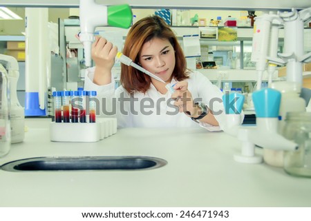 Young female tech or women science working and holding pipette in biological laboratory