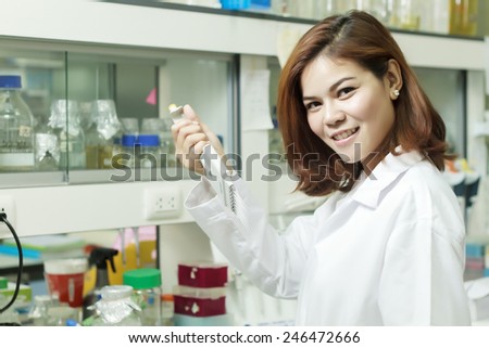 Young female tech or women asia scientist working with multichannel pipette in biological laboratory