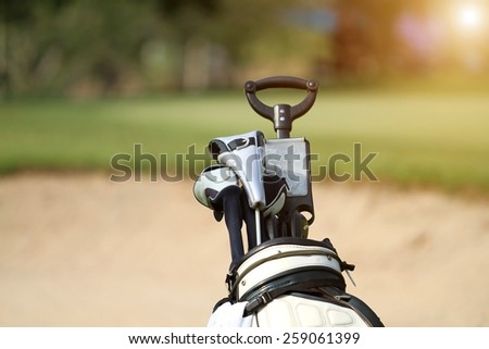golf bag and professional golf gear on the golf course at sunset