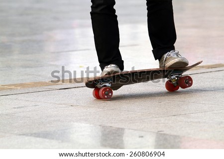 Skateboarder doing a skateboard trick and Legs in sneakers on a skateboard