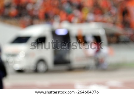 blurry ambulance car stand by at football stadium for help