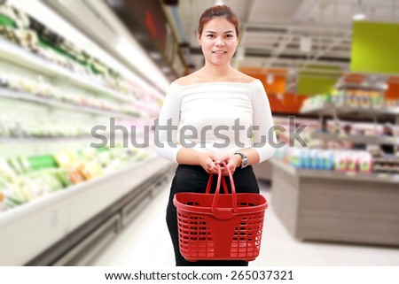 happiness, consumerism, sale and people concept - smiling young woman Asian with shopping basket and buy vegetable/fruit at supermarket/mall