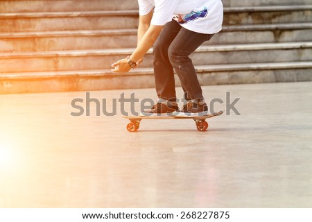 blurry Skateboarder doing a skateboard trick and Legs in sneakers on a skateboard