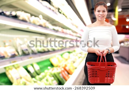 happiness, consumerism, sale and people concept - smiling young woman Asian with shopping basket and buy vegetable/fruit at supermarket/mall