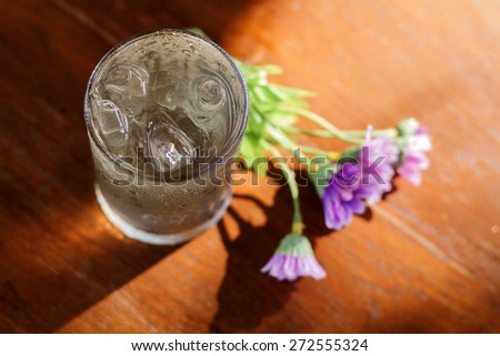 glass of water and fake flower on wood table
