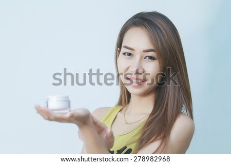 A beautiful woman asia using a skin care product, moisturizer or lotion and Skincare taking care of her dry complexion. Moisturizing cream in female hands .