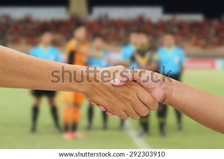 handshake in a business on referee with captain team and opponent team players shaking hand on football stadium background