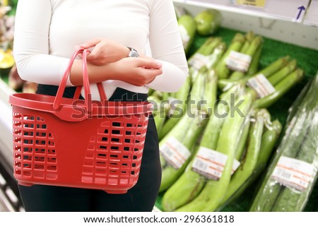close up woman Asian with shopping basket and buy vegetable/fruit at supermarket/mall