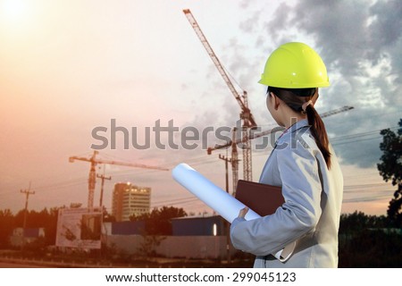portrait women asia engineer working and holding blueprints at construction site