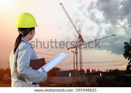 portrait women asia engineer working and holding blueprints at construction site