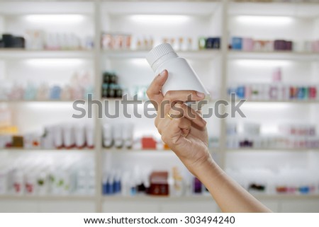 hand of doctor holding medicine bottle on  medicine cabinet and store medicine and pharmacy drugstore