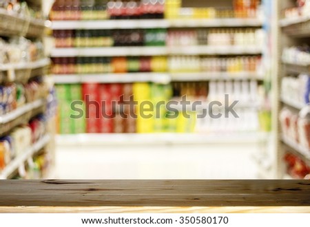 Wood table top on Blurry of supermarket/mall for background and shopping fashion and shopping food