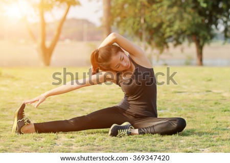 Blurry and soft focus of Athletic woman asia warming up and Young female athlete sitting on an exercising and stretching in a park before Runner outdoors, healthy lifestyle concept