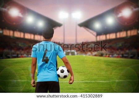 football player and soccer player holding ball on football stadium and stadium arena soccer field championship win for background,blurry and soft focus