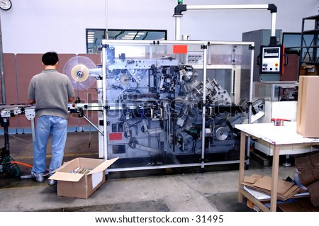 Man working at a DVD / CD shrink wrap machine