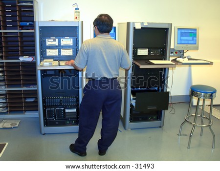 Man working at a computer station in a DVD glass mastering lab