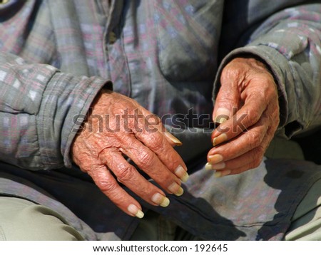Hands of an old man who sits alone passing time, time that appears to be running out