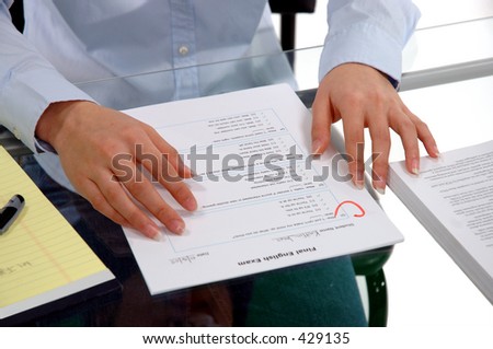 Hands of a female student holding a fictional English Exam with a C grade