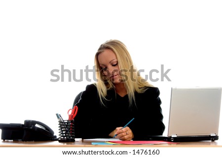 Strong and beautiful corporate executive at her desk taking business notes from her laptop computer