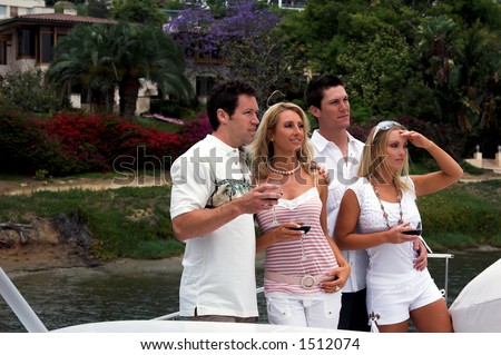 a group of two men and two women celebrating life with a toast  during a yacht party