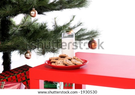 A plate of chocolate chip cookies and a glass of milk beside the Christmas tree await the arrival of Jolly Saint Nick