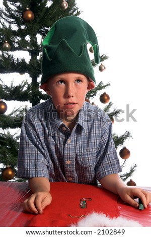 A perplexed young elf working on a Christmas craft project of decorating a stocking rolls his eyes