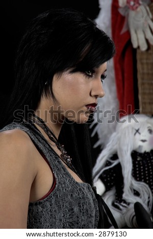 Beautiful raven haired Gothic Vampire girl in a black and grey dress and striking green eyes.
