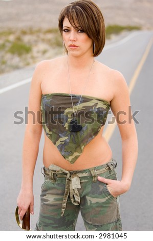 Portrait of a woman with a sword in fatigues in the desert