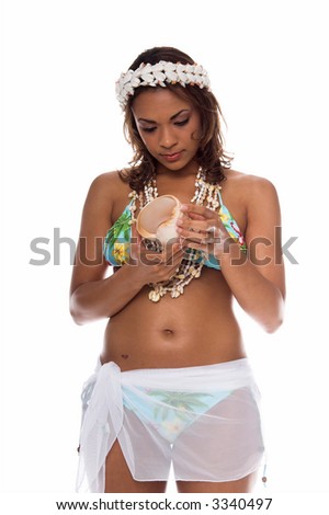 Pretty Island girl in a bikini top, shell necklaces and a crown of shells examining a small Conch shell