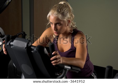 Beautiful blond woman during a cardio workout on an exercise bike in the gym