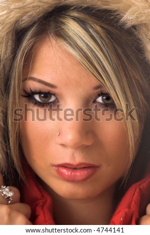 Head shot of a beautiful young girl in a red parka with a fur trimmed hood