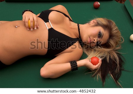 Sexy young Asian bikini model laying on her side on top of a pool table