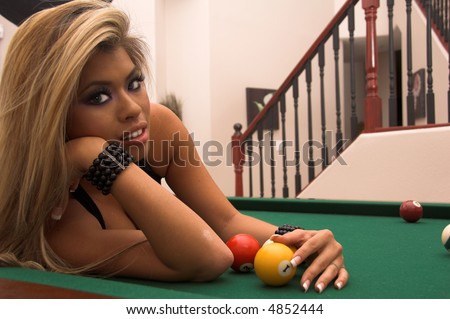 Sexy young Asian bikini model laying on her elbows and on her side on top of a pool table